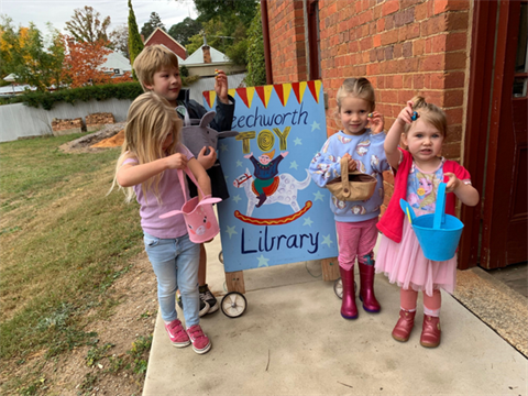 Four children standing and holding a sign for Beechworth Toy Library